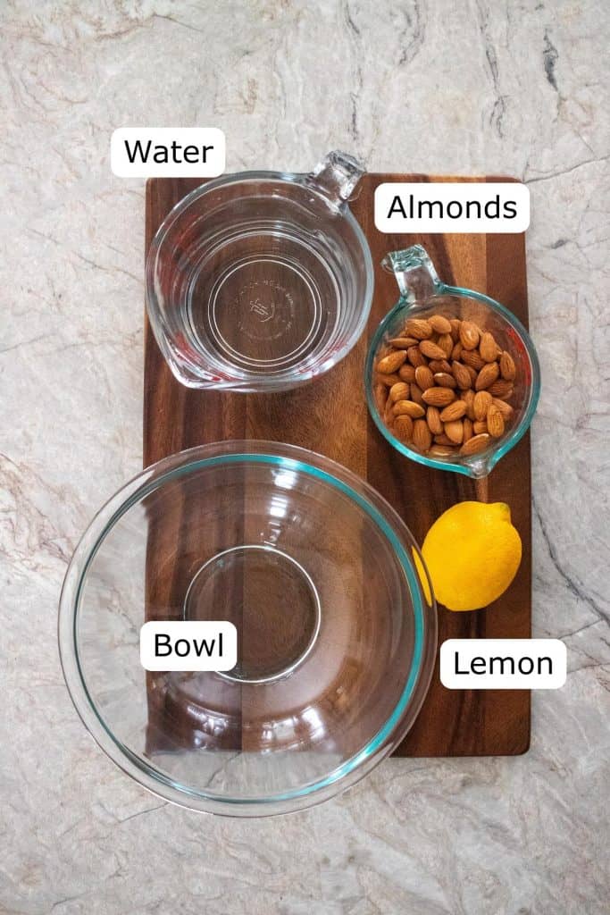 Water, almonds, a lemon, and a mixing bowl