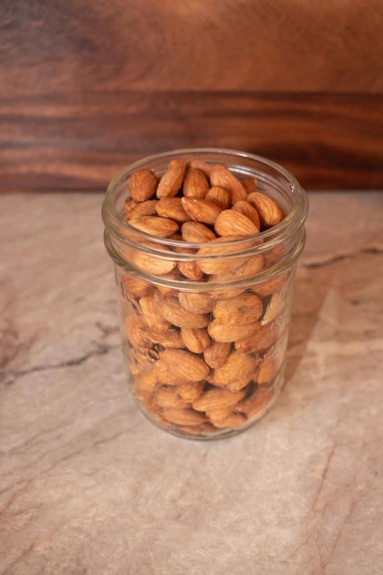 Mason jar filled with raw, soaked and dehydrated almonds