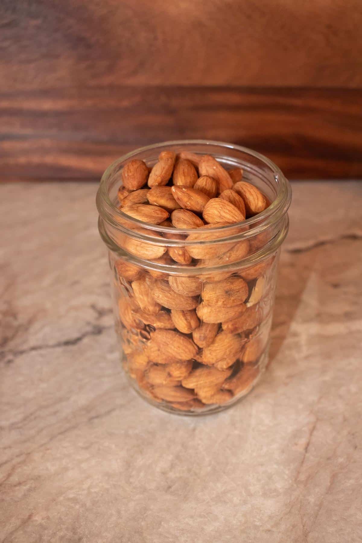 Mason jar filled with raw, soaked and dehydrated almonds