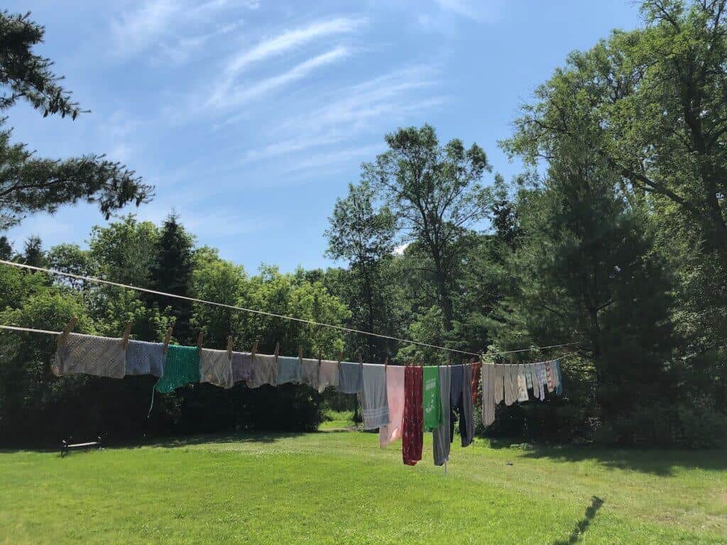 clothes hanging on an outdoor clothesline, with the blue sky and green grass in the background