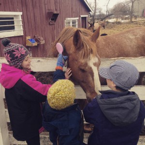 3 kids petting a horse