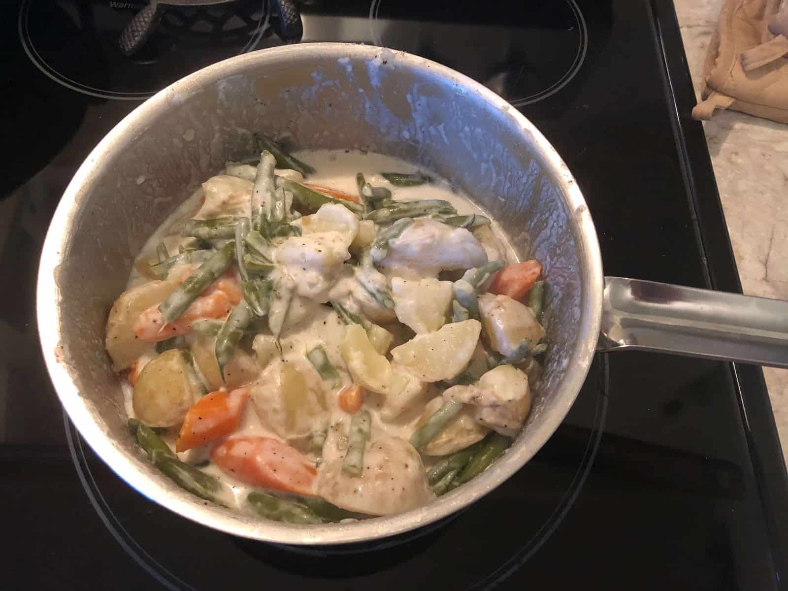 potatoes, carrots and green beans in a creamy sauce