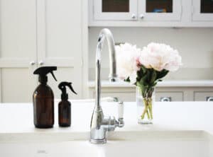 natural cleaning sprays at a kitchen sink with flowers