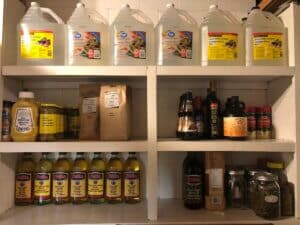 vinegar, mustard, olive oil, olives etc on a white shelf