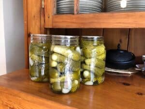 Jars of homemade pickles on an old fashioned hutch
