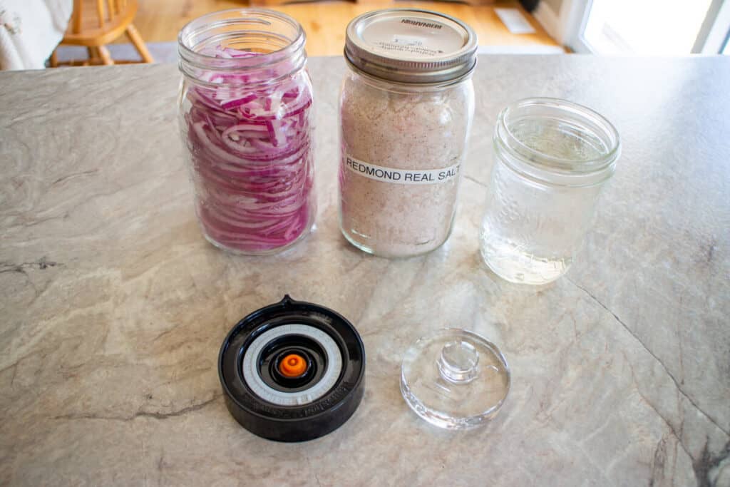 Jar of red onions, jar of sea salt, jar of water, easy fermenter lid and glass weight