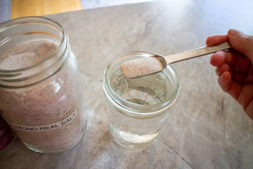 Adding 1 tsp of sea salt to a jar of water