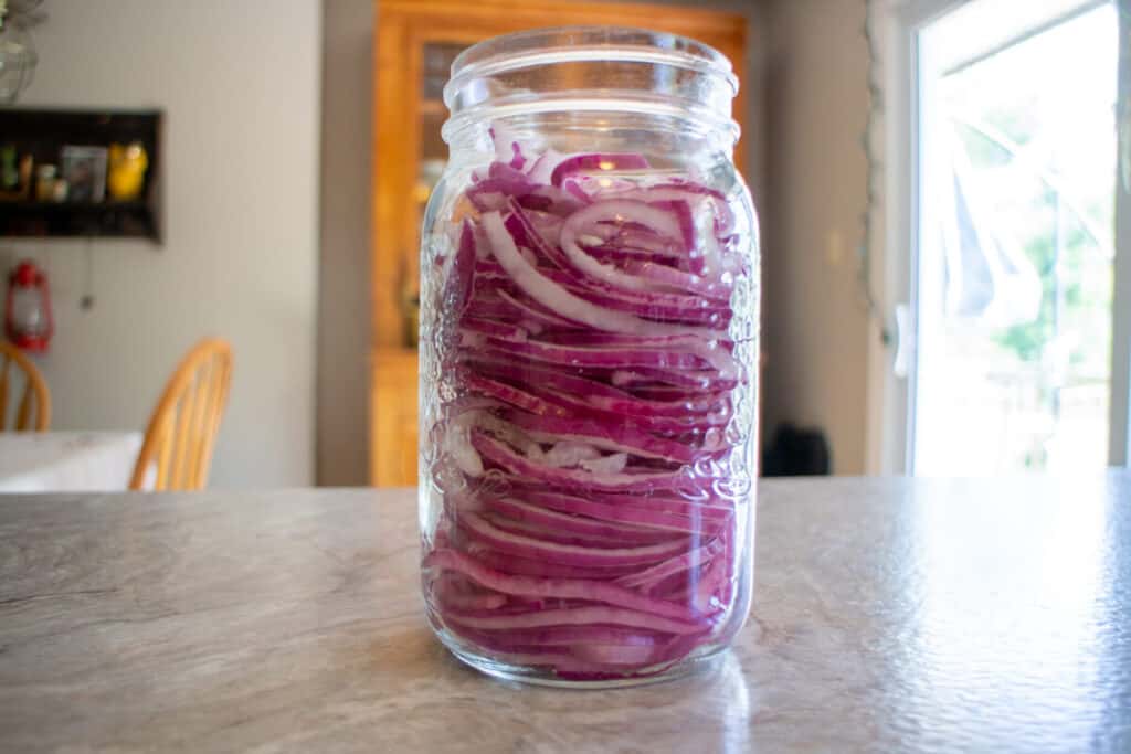 Quart sized mason jar full of red onion slices