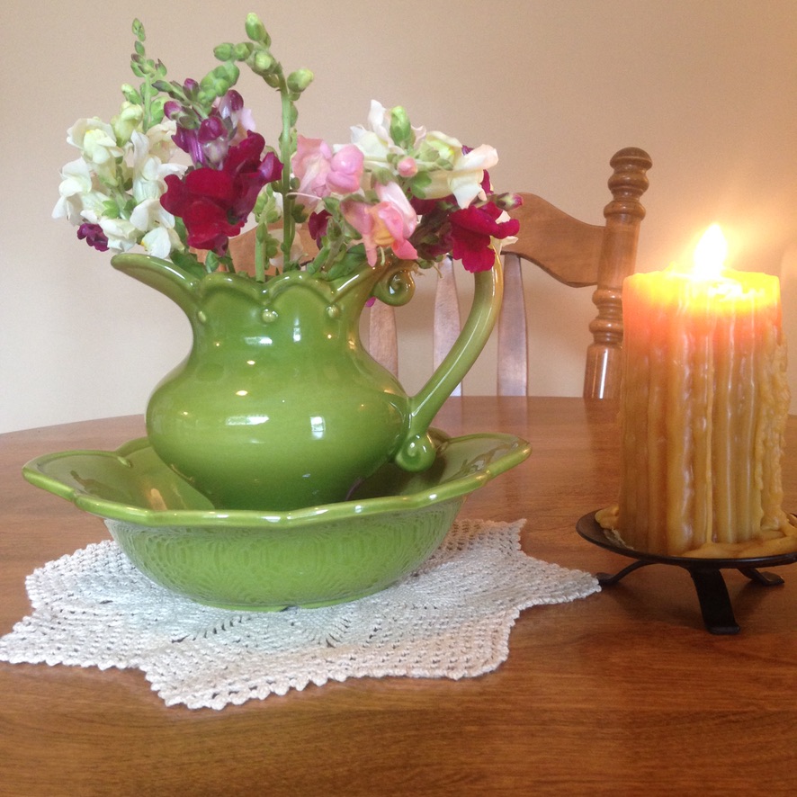green wash basin with flowers, a beeswax candle
